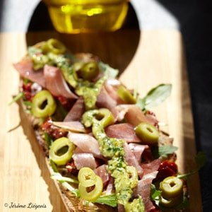 Tartine pesto, tomates confites, jambon de pays, roquette et olives